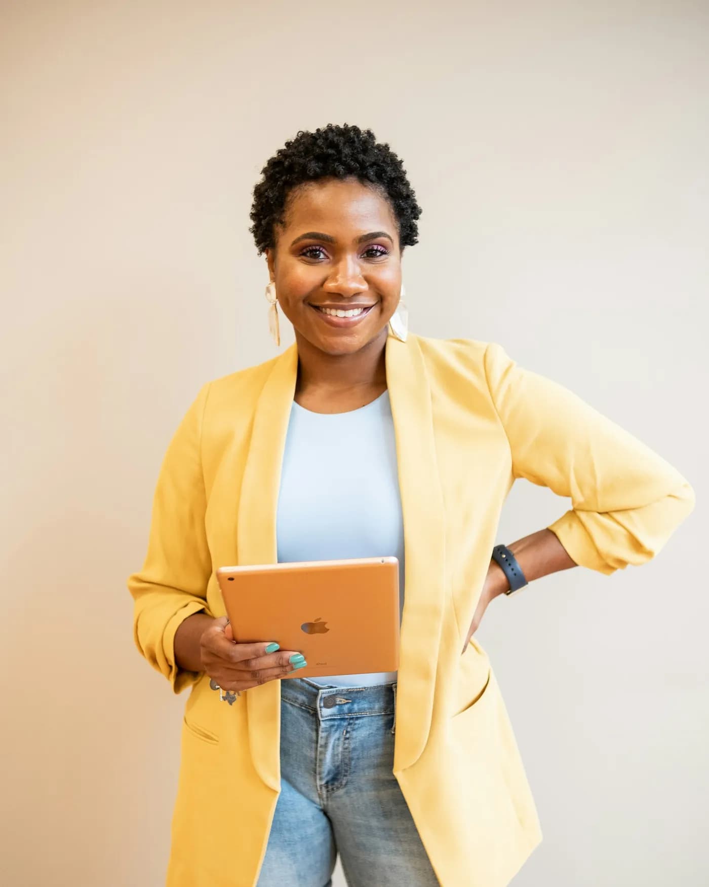A Nigerian woman professional smiling, holding a tablet